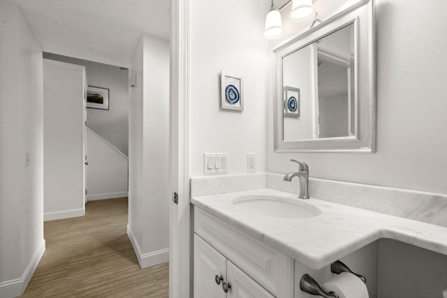 bathroom featuring wood finished floors, baseboards, and vanity