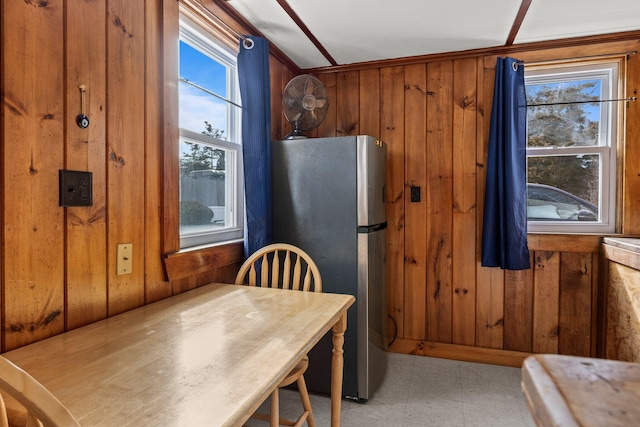 kitchen with light floors, wood walls, and freestanding refrigerator