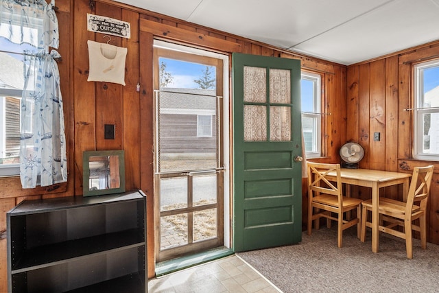 doorway to outside with wood walls