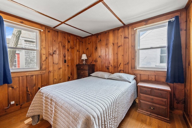 bedroom with wood walls and wood finished floors