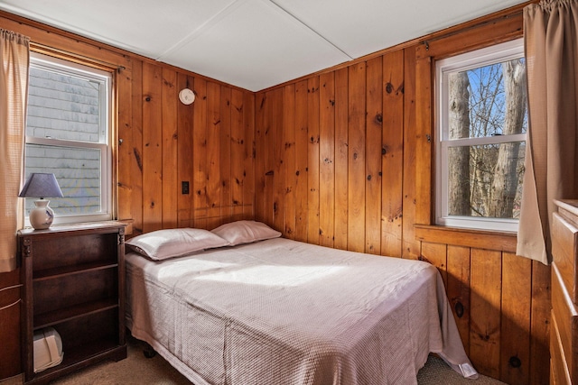 bedroom featuring wooden walls and carpet flooring