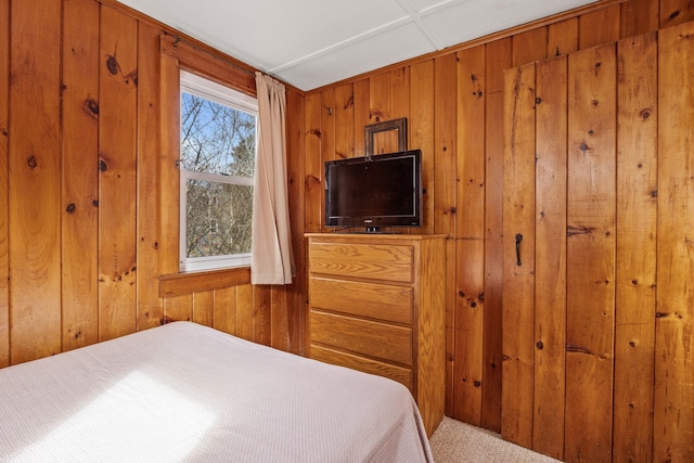 carpeted bedroom featuring wood walls