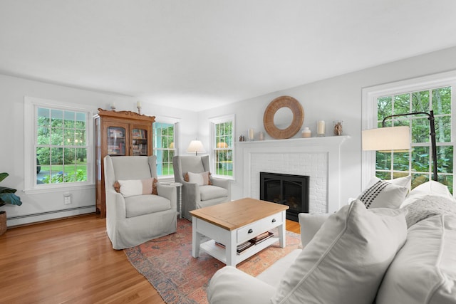 95 Red Brook Rd, Waquoit, MA 02536 - living area featuring a baseboard radiator, plenty of natural light, wood finished floors, and a brick fireplace