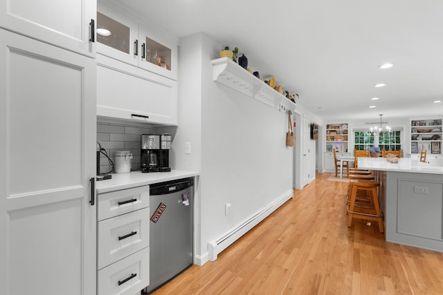 95 Red Brook Rd, Waquoit, MA 02536 - kitchen with a baseboard heating unit, white cabinets, light countertops, light wood-style flooring, and tasteful backsplash