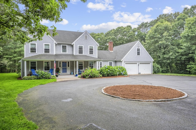 95 Red Brook Rd, Waquoit, MA 02536 - view of front of house with driveway, covered porch, a garage, a front yard, and a chimney