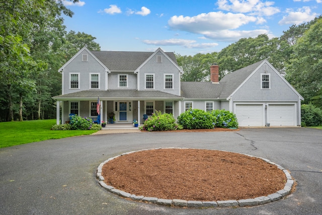 95 Red Brook Rd, Waquoit, MA 02536 - view of front facade featuring curved driveway, a porch, a garage, a chimney, and a front lawn
