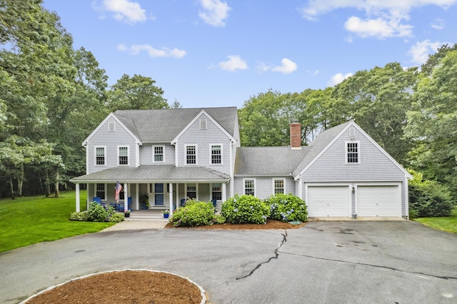 95 Red Brook Rd, Waquoit, MA 02536 - view of front of property featuring a porch, asphalt driveway, a chimney, a front yard, and view of wooded area