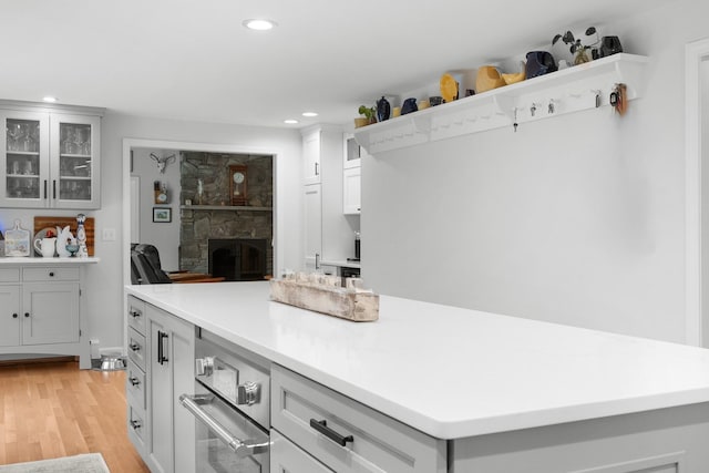 95 Red Brook Rd, Waquoit, MA 02536 - kitchen featuring a fireplace, light wood-style floors, a kitchen island, recessed lighting, and light countertops