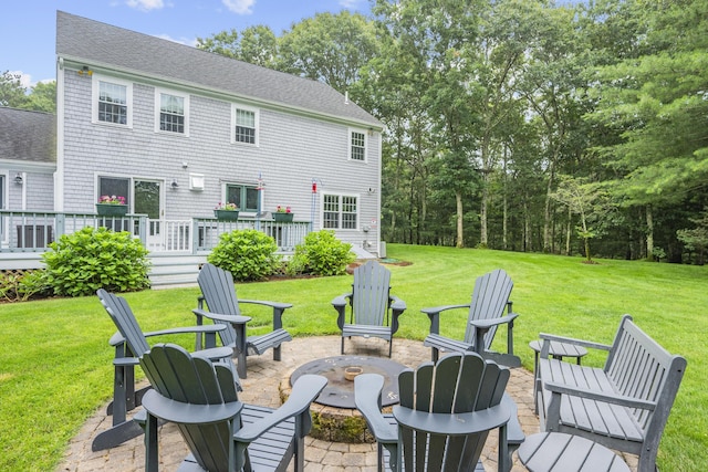 95 Red Brook Rd, Waquoit, MA 02536 - back of property with a fire pit, a deck, roof with shingles, and a yard
