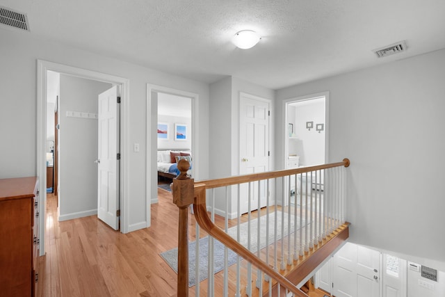 95 Red Brook Rd, Waquoit, MA 02536 - corridor featuring an upstairs landing, light wood finished floors, and a textured ceiling