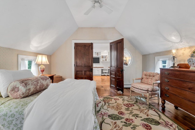 37 Tobisset St, Mashpee, MA 02649 - bedroom with wallpapered walls, wood finished floors, vaulted ceiling, a baseboard heating unit, and a ceiling fan