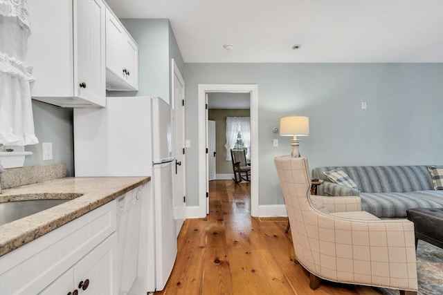 37 Tobisset St, Mashpee, MA 02649 - kitchen featuring white cabinets, light wood-type flooring, light stone counters, white appliances, and open floor plan