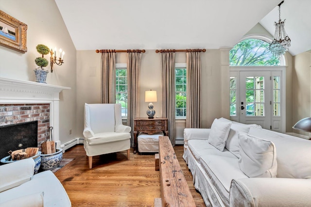37 Tobisset St, Mashpee, MA 02649 - living room with healthy amount of natural light, baseboard heating, a brick fireplace, light wood-style floors, and high vaulted ceiling