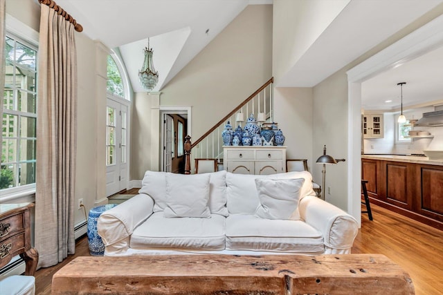 37 Tobisset St, Mashpee, MA 02649 - living room featuring light wood-style floors, stairs, vaulted ceiling, and a baseboard radiator