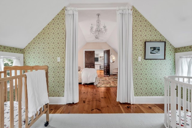 37 Tobisset St, Mashpee, MA 02649 - corridor with vaulted ceiling, wallpapered walls, wood finished floors, and a chandelier
