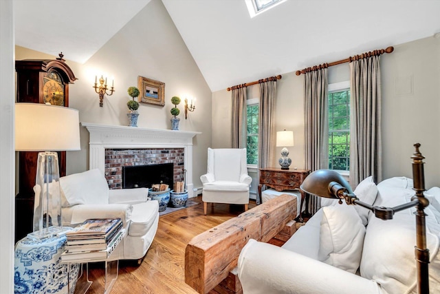 37 Tobisset St, Mashpee, MA 02649 - living room with wood finished floors, a fireplace, a skylight, high vaulted ceiling, and a baseboard heating unit