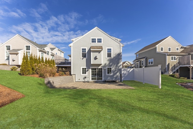 rear view of property featuring fence, a lawn, and a patio