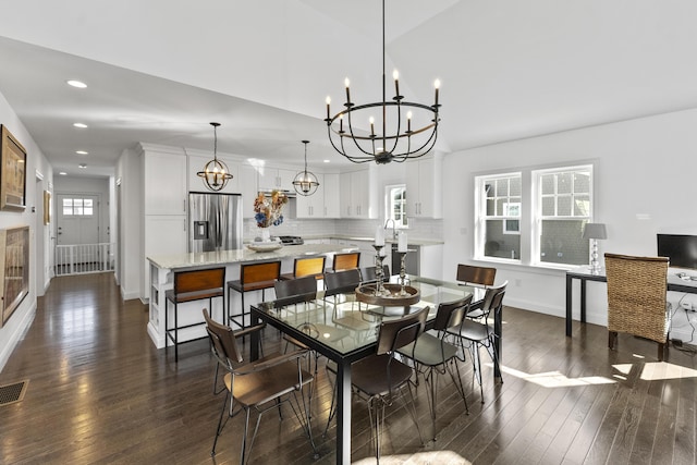 dining area with an inviting chandelier, visible vents, baseboards, and dark wood-style flooring