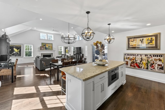 kitchen featuring dark wood-type flooring, a fireplace, a kitchen island, and recessed lighting