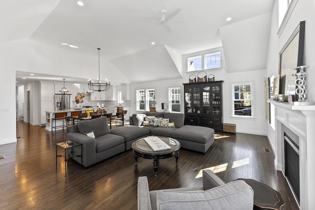 living room with a fireplace, high vaulted ceiling, and dark wood-style flooring