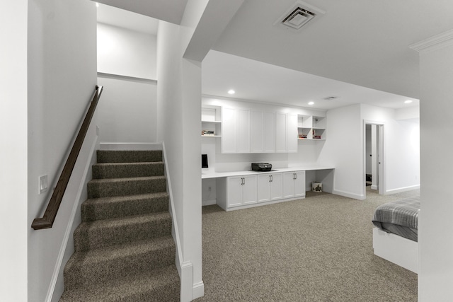 stairs with baseboards, visible vents, built in study area, carpet flooring, and recessed lighting