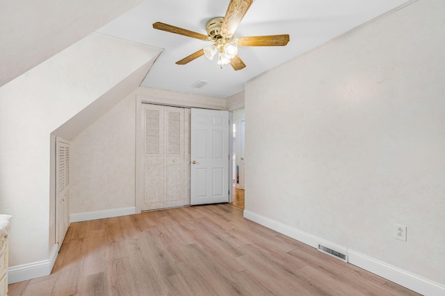 additional living space with baseboards, ceiling fan, wood finished floors, and visible vents