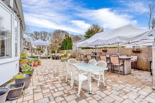 view of patio / terrace featuring a fenced backyard, outdoor dry bar, and outdoor dining area