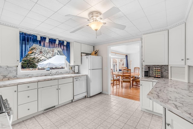 kitchen featuring decorative backsplash, white appliances, and white cabinets