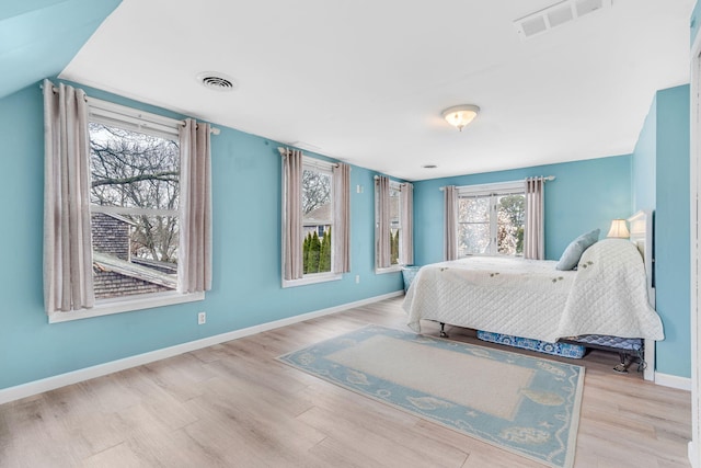 bedroom featuring baseboards, wood finished floors, and visible vents