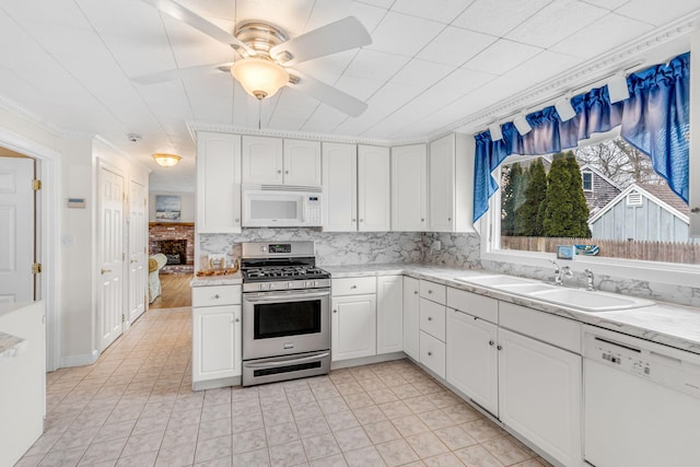 kitchen featuring ceiling fan, a sink, white cabinets, white appliances, and light tile patterned flooring
