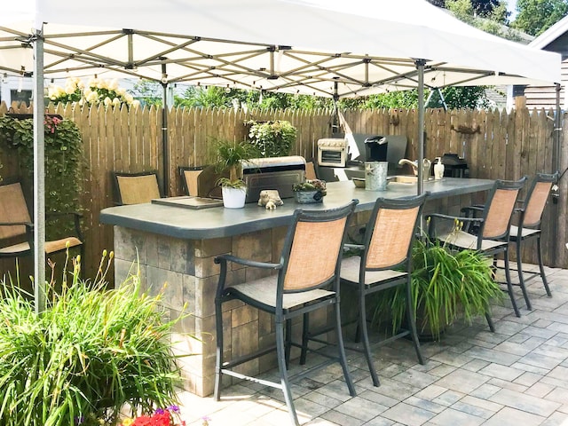 view of patio / terrace featuring fence and outdoor dry bar