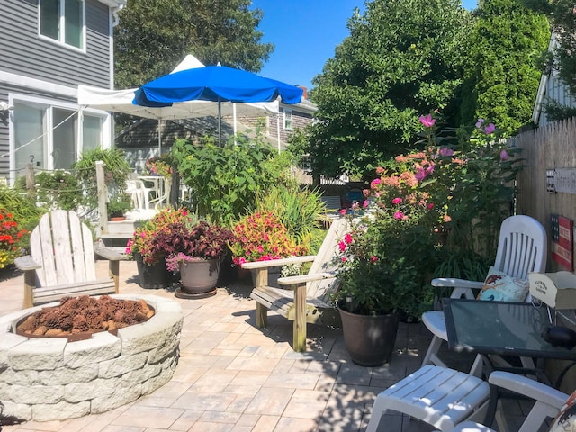 view of patio featuring an outdoor fire pit and fence