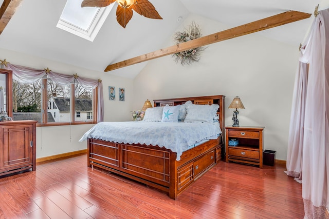bedroom with a skylight, baseboards, ceiling fan, and wood finished floors