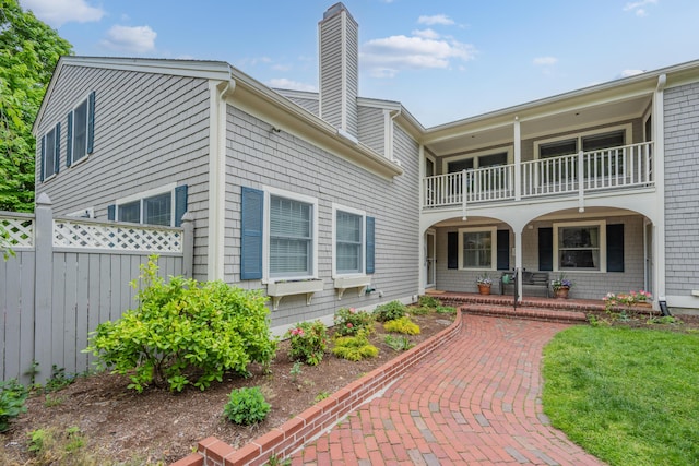 925 Main St Unit 3, Cotuit, MA 02635 - view of front of property with a balcony, covered porch, fence, and a chimney