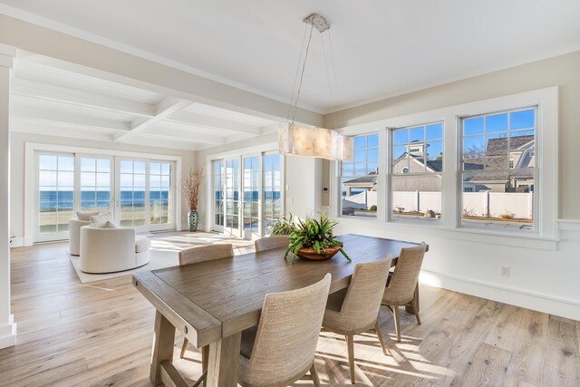 dining area featuring coffered ceiling, a water view, beamed ceiling, and light hardwood / wood-style flooring