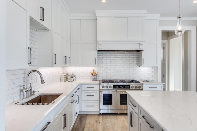 kitchen with sink, double oven range, decorative backsplash, and pendant lighting