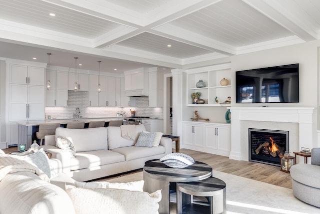 living room featuring coffered ceiling, beamed ceiling, light hardwood / wood-style flooring, and crown molding