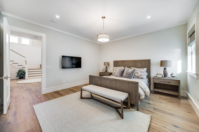 bedroom with light hardwood / wood-style flooring and crown molding