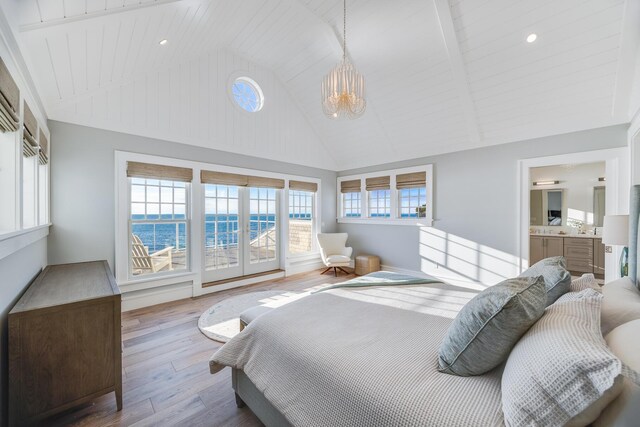 bedroom featuring hardwood / wood-style floors, ensuite bath, wood ceiling, a water view, and high vaulted ceiling