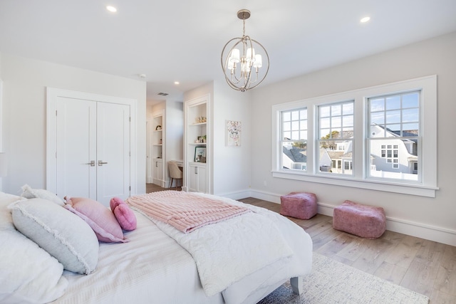 bedroom featuring light hardwood / wood-style flooring and a chandelier