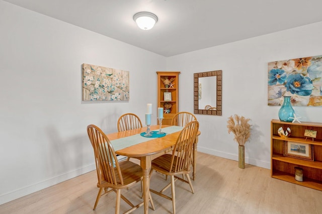 dining room with baseboards and light wood-type flooring