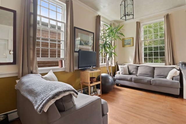 living room featuring crown molding, light hardwood / wood-style floors, plenty of natural light, and an inviting chandelier