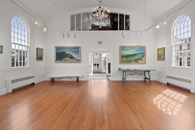 entryway featuring radiator heating unit, an inviting chandelier, and hardwood / wood-style floors