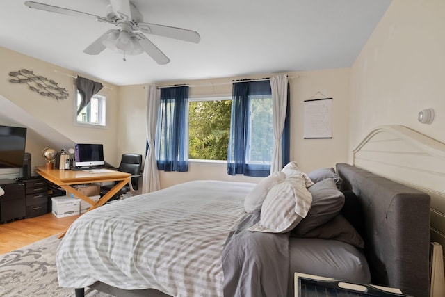 bedroom with ceiling fan, multiple windows, and hardwood / wood-style floors