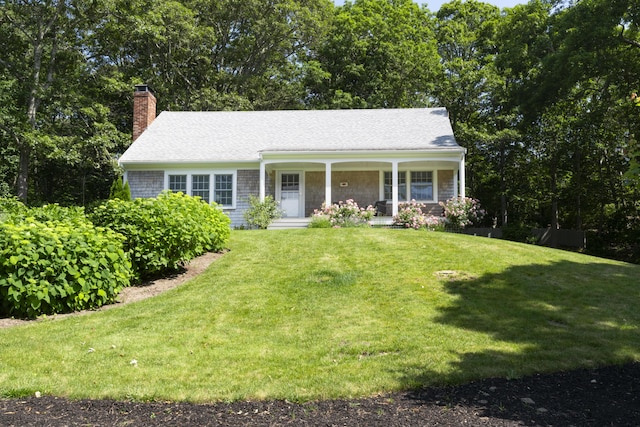 15 Wood Valley Rd, Chatham, MA 02633 - view of front facade featuring covered porch, a chimney, a front lawn, and roof with shingles