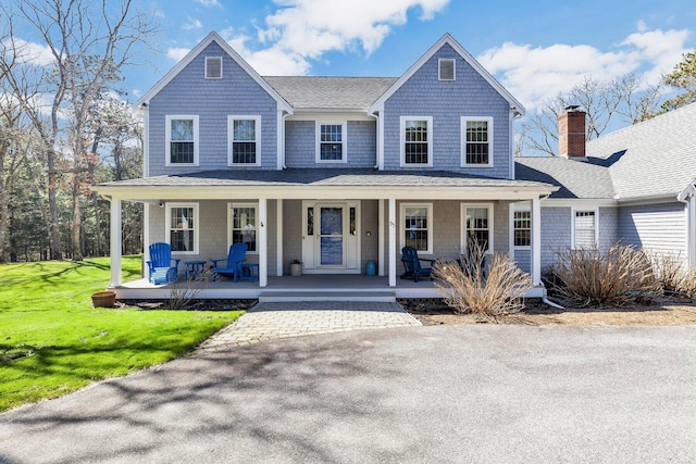 95 Red Brook Rd, Waquoit, MA 02536 - farmhouse inspired home with a front yard, a porch, a chimney, and a shingled roof