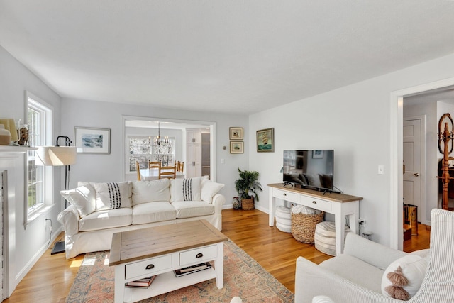 95 Red Brook Rd, Waquoit, MA 02536 - living room featuring baseboards, light wood finished floors, and a chandelier