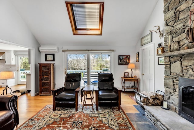 95 Red Brook Rd, Waquoit, MA 02536 - living area with a wall mounted air conditioner, a fireplace, vaulted ceiling with skylight, and light wood finished floors