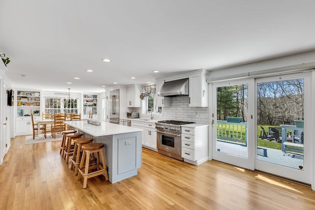 95 Red Brook Rd, Waquoit, MA 02536 - kitchen with wall chimney range hood, light countertops, white cabinets, stainless steel appliances, and a sink