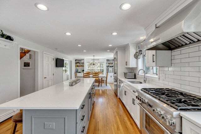 95 Red Brook Rd, Waquoit, MA 02536 - kitchen featuring a sink, wall chimney range hood, high end stainless steel range oven, recessed lighting, and a kitchen island